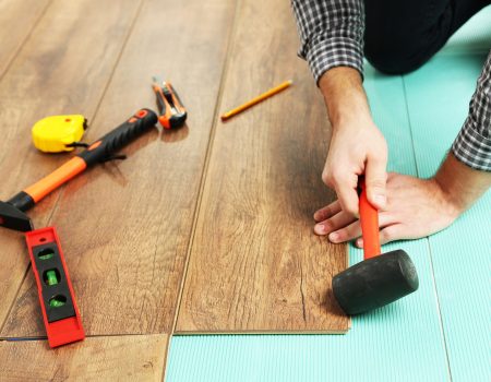 Carpenter worker installing laminate flooring in the room Carpenter worker installing laminate flooring in the room